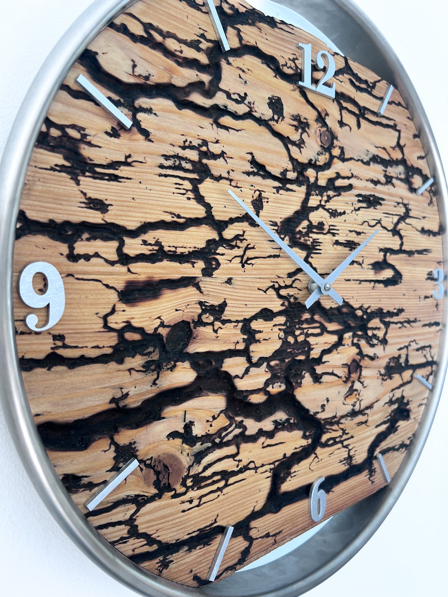 Detailaufnahme der künstlich erzeugten Blitzstruktur im Fichtenholz der handgefertigten Wanduhr NO 574