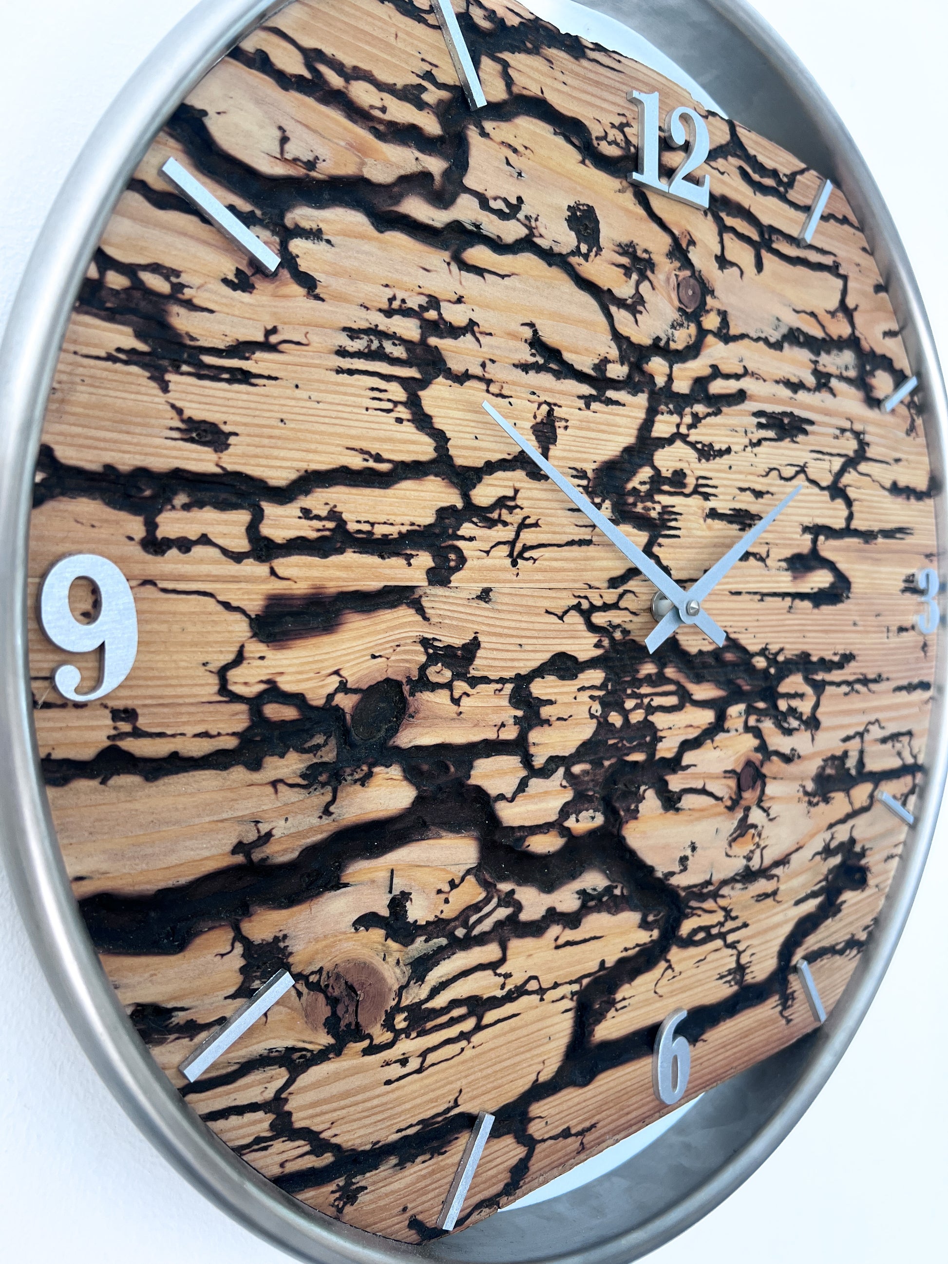 Detailaufnahme der künstlich erzeugten Blitzstruktur im Fichtenholz der handgefertigten Wanduhr NO 574